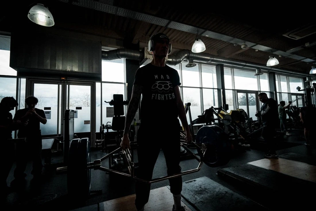 Silhouette d’un athlète à l’entraînement dans une salle sombre.