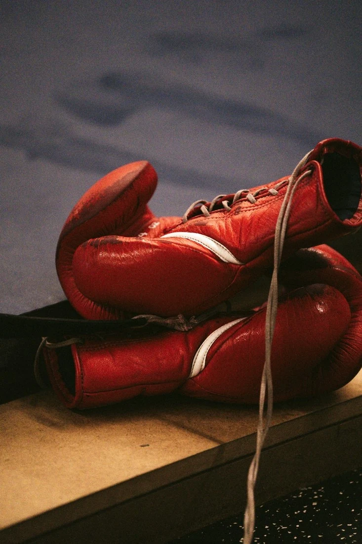 Une paire de gants de boxe rouges posée sur un banc.